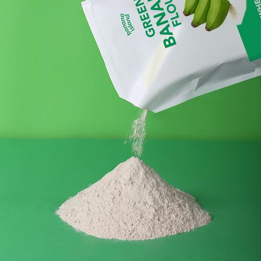 Green Banana Flour Powder being poured from a white bag with green text on a green background